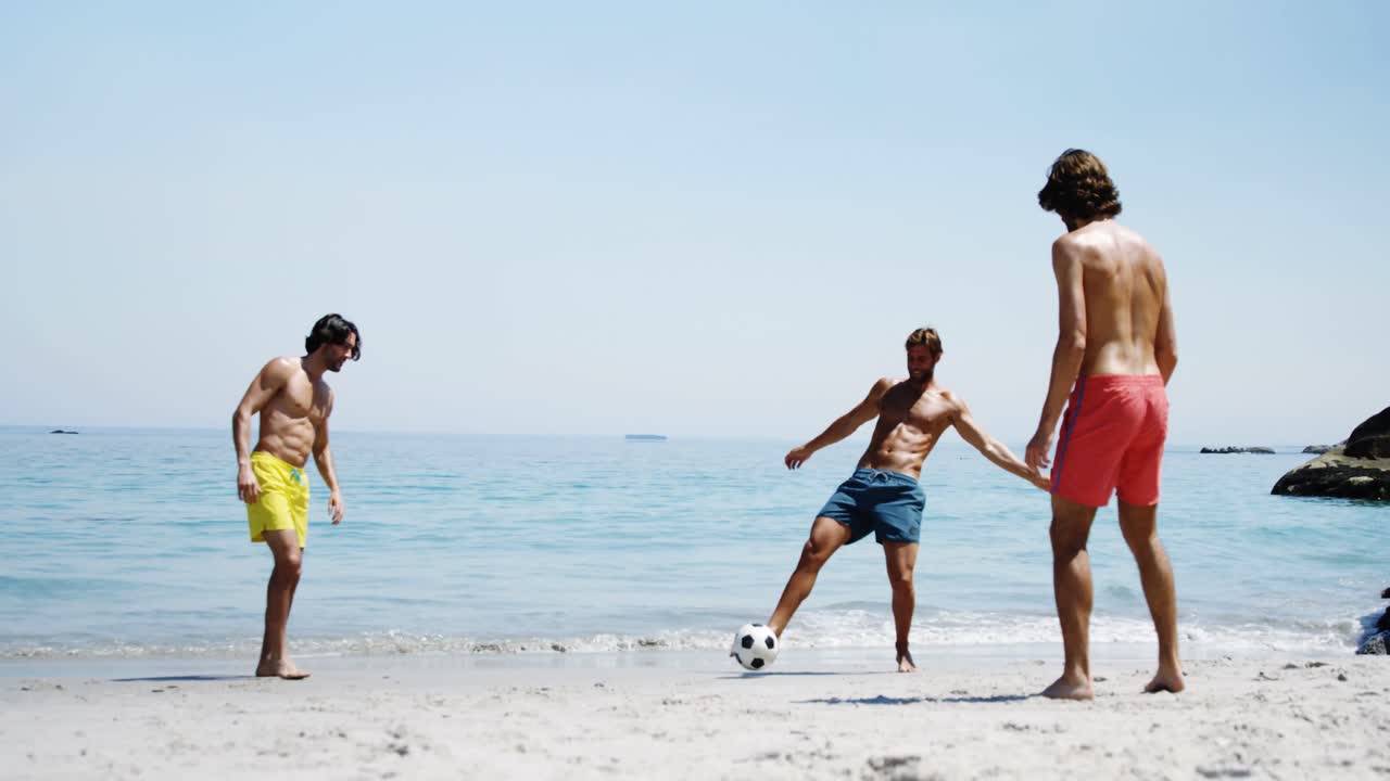 amigos jugando al fútbol en la playa