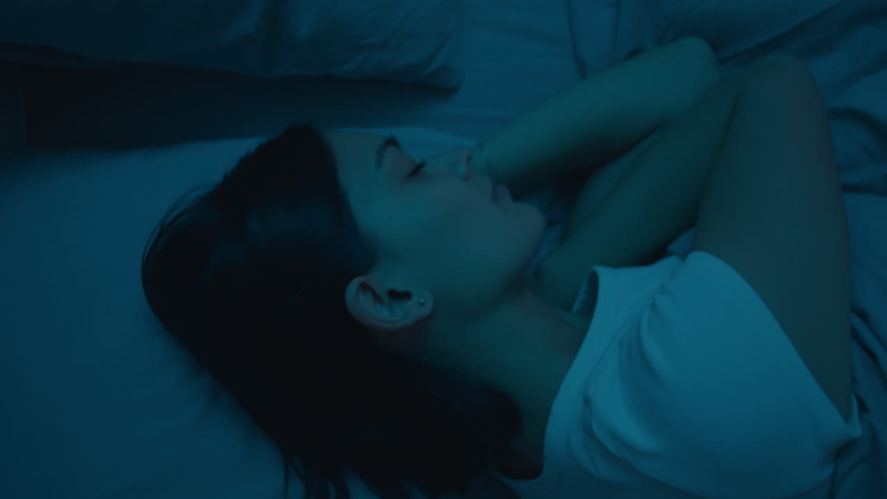 Young Woman Sleeping in Bed at Night