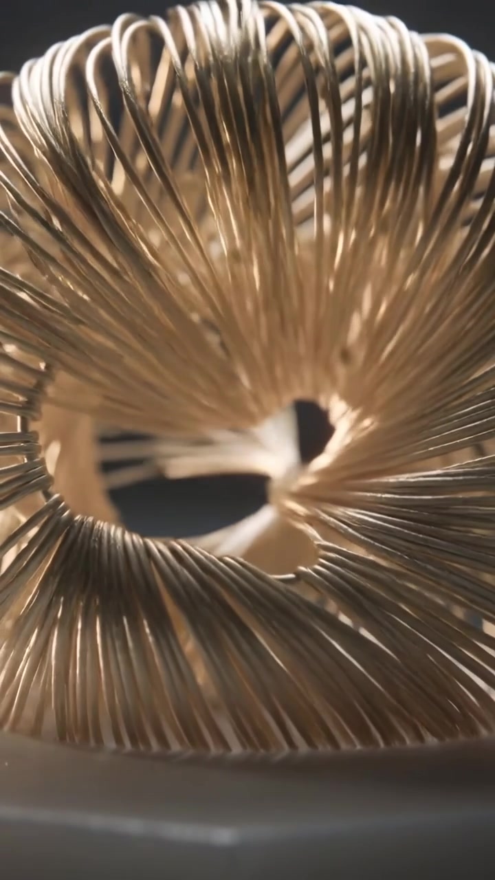 Vertical video: Moving camera tracking strands fanning into woven torus on base, revealing hole