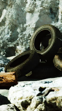 discarded tires on a rocky beach