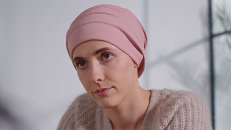 close up of serious young woman patient wearing headscarf undergoing chemotherapy treatment for breast cancer meeting with oncologist or doctor in hospital 3