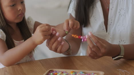 mother and daughter making jewelry together