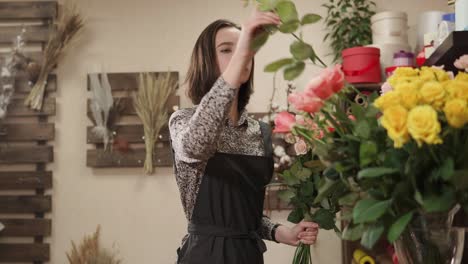 workwoman of floral studio is making decor of roses in a workshop