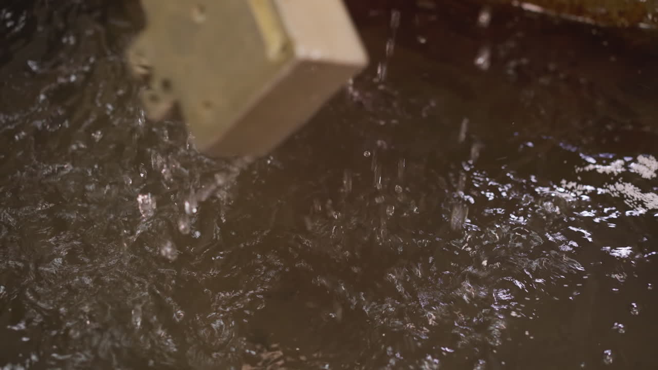 Worker in a protective suit opening a high-temperature kiln at a metal foundry