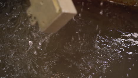 worker in a protective suit opening a high-temperature kiln at a metal foundry