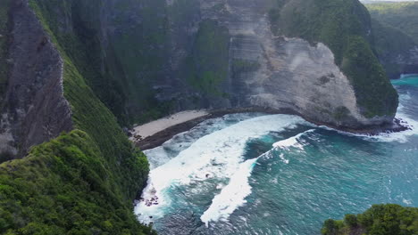 waves crashing on a small beach surrounded by cliffs in bali