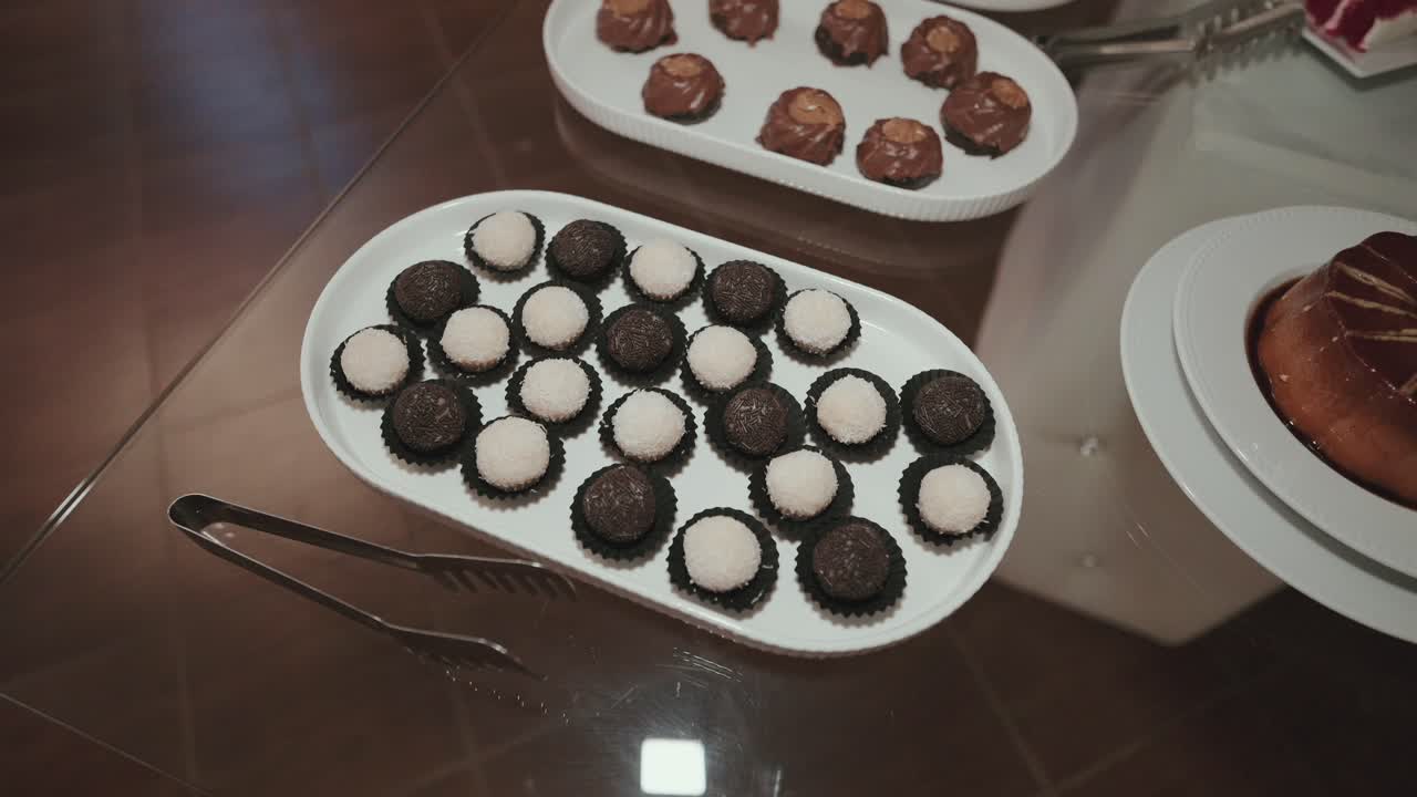 Close up of assorted black and white wedding truffles arranged neatly on a platter at dessert table