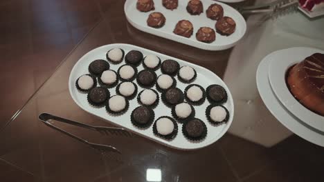 close up of assorted black and white wedding truffles arranged neatly on a platter at dessert table