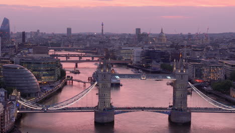 die beleuchtete stadt london in der dämmerung mit der tower bridge über die themse, luftaufnahme