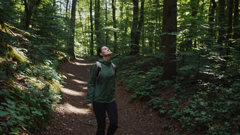 woman enjoying peace and fresh air in a sunlit forest