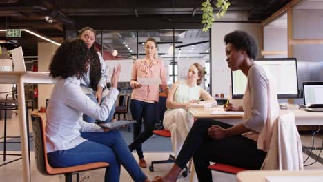 diverse female business creatives discussing project at work, in slow motion