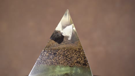 orgonite crystal pyramid rotating against bokeh background