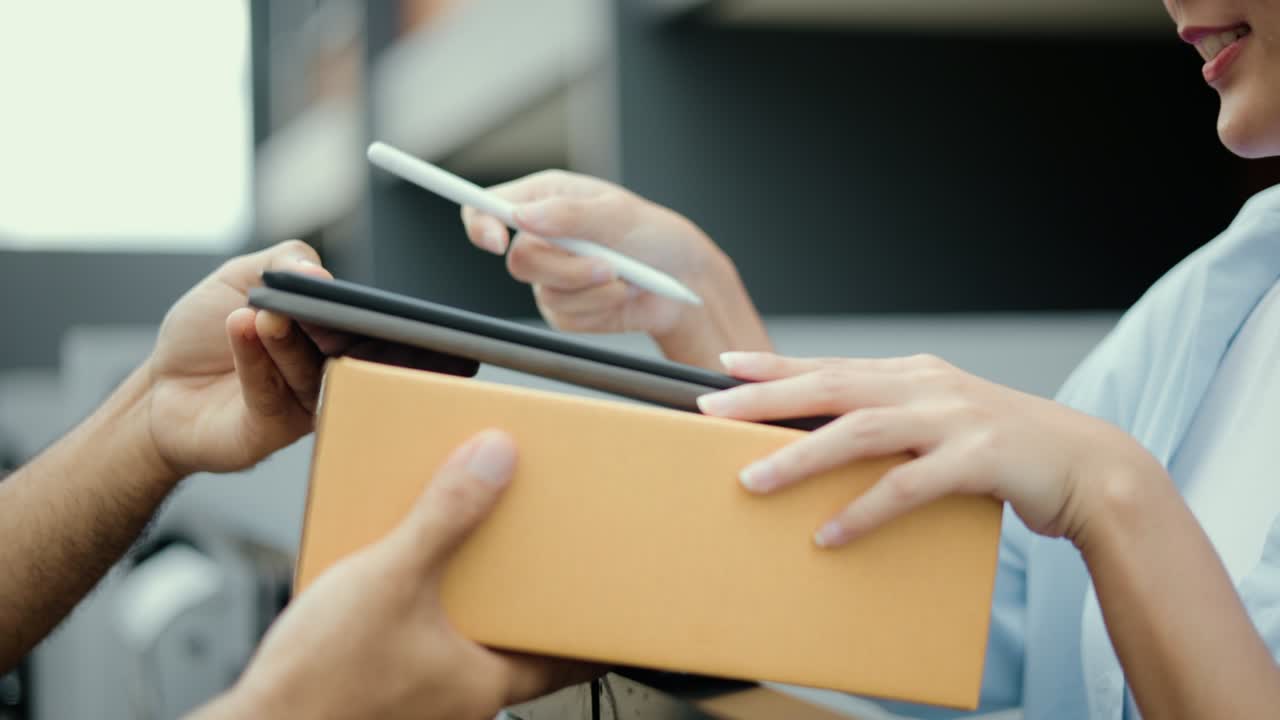 mujer de mano firmando firma electrónica en la tableta para el acuerdo del contrato digital recibiendo el paquete del hombre de entrega azul de las compras en línea. mensajero hombre entregando el paquete al destino.