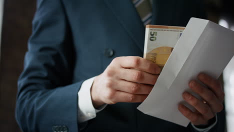 businessman taking euro envelope indoors close up. manager received bribe.