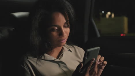 mujer usando teléfono inteligente en el asiento trasero