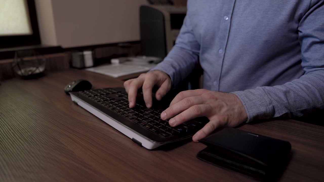 el hombre de negocios se sienta en la mesa, toma su tarjeta de crédito y comienza a escribir en el teclado, usa su tarjeta de credito para pagar en línea.