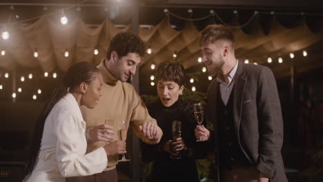 group of happy multiethnic friends celebrating new year countdown together and toasting with champagne glasses