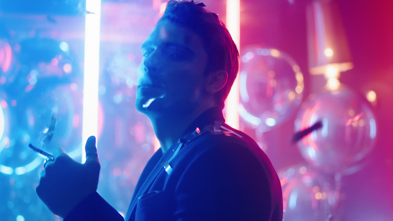 hombre atractivo mirando la cámara en la fiesta. hombre bailando bajo confeti en el club