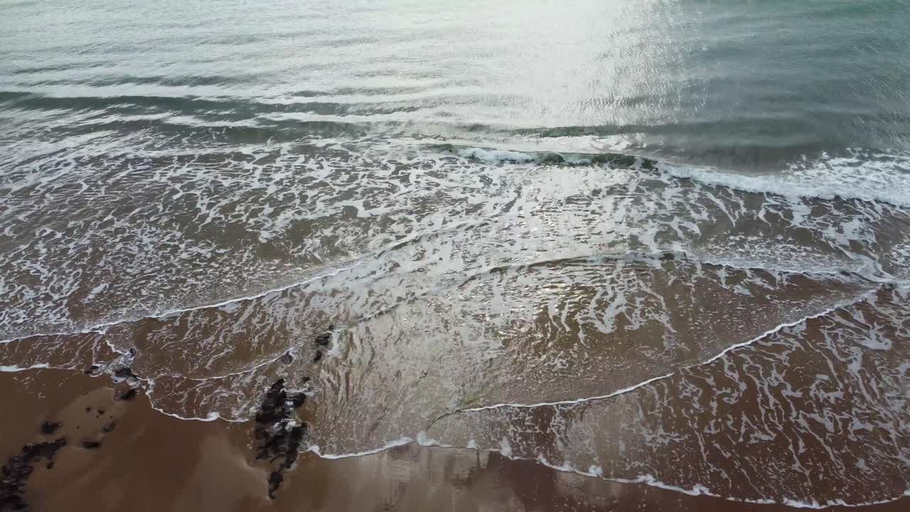 наклонная съемка открытого океана с беспилотного летательного аппарата с небом и солнцем, отражающимися на пляже и море uk 4k