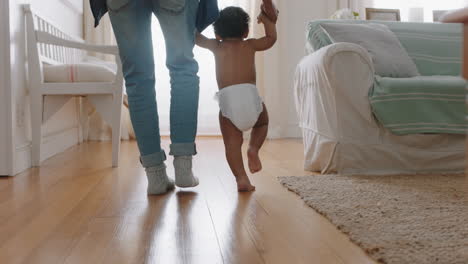 baby learning to walk toddler taking first steps with father helping infant teaching child at home