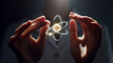 hands holding an atom