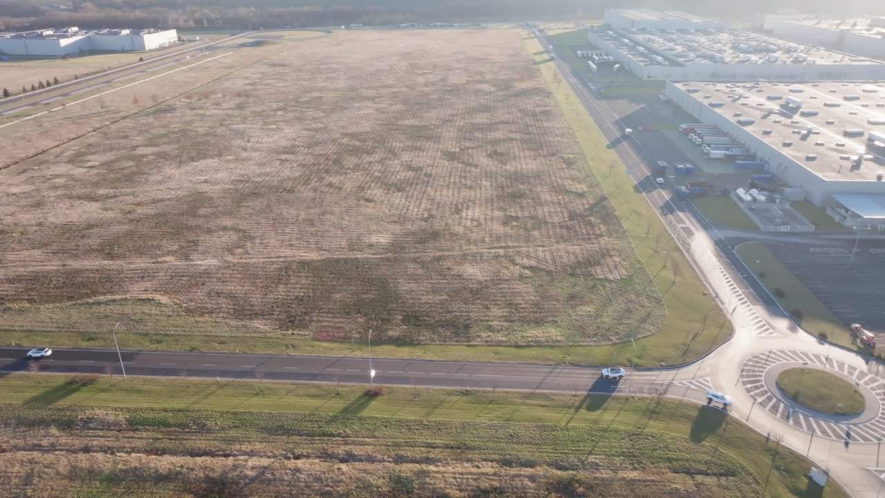 Aerial - roundabout intersection near large manufacturing building