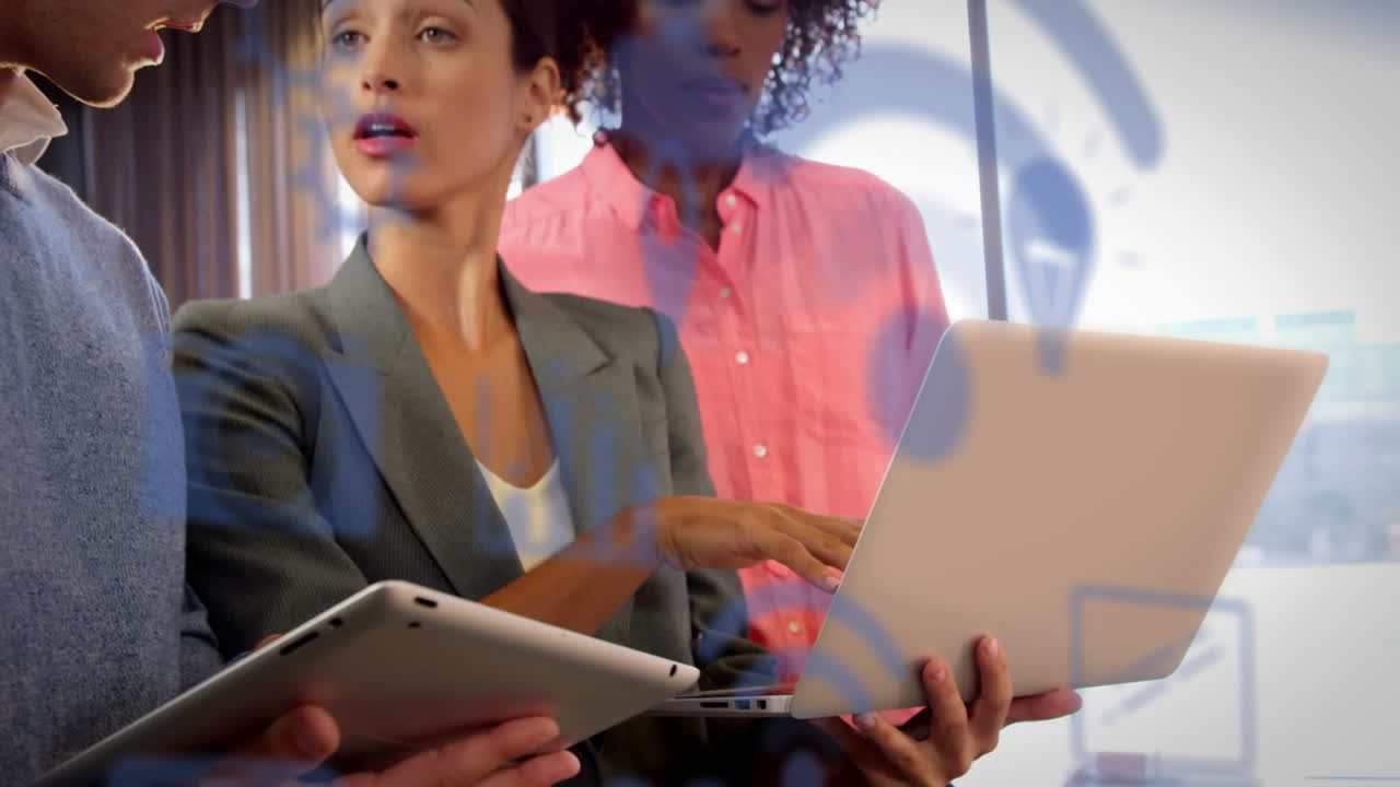Animazione di più icone digitali su colleghi diversi che discutono davanti a un laptop in ufficio
