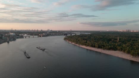 Aerial-view-of-the-Dnipro-river-with-ships-and-the-city-of-Kiev-behind