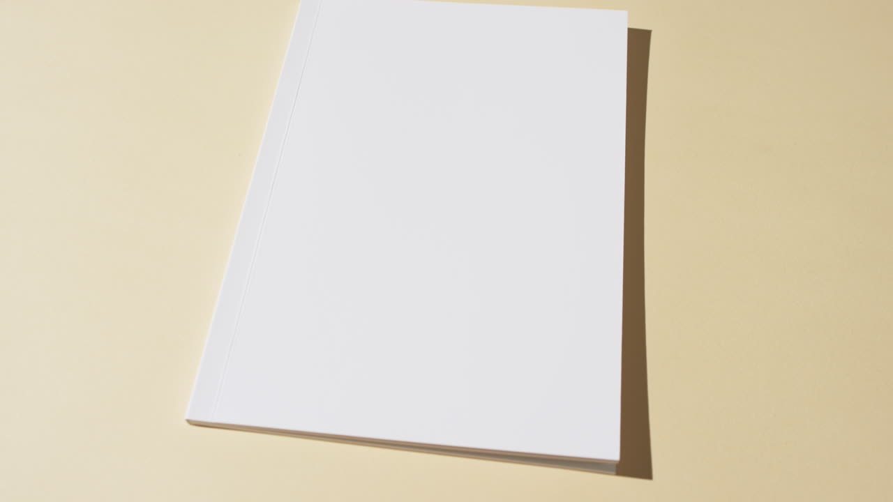 video de un libro con páginas blancas y espacio de copia en fondo amarillo