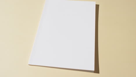 video of book with blank white pages and copy space on yellow background