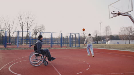 joven discapacitado jugando al baloncesto con su amigo