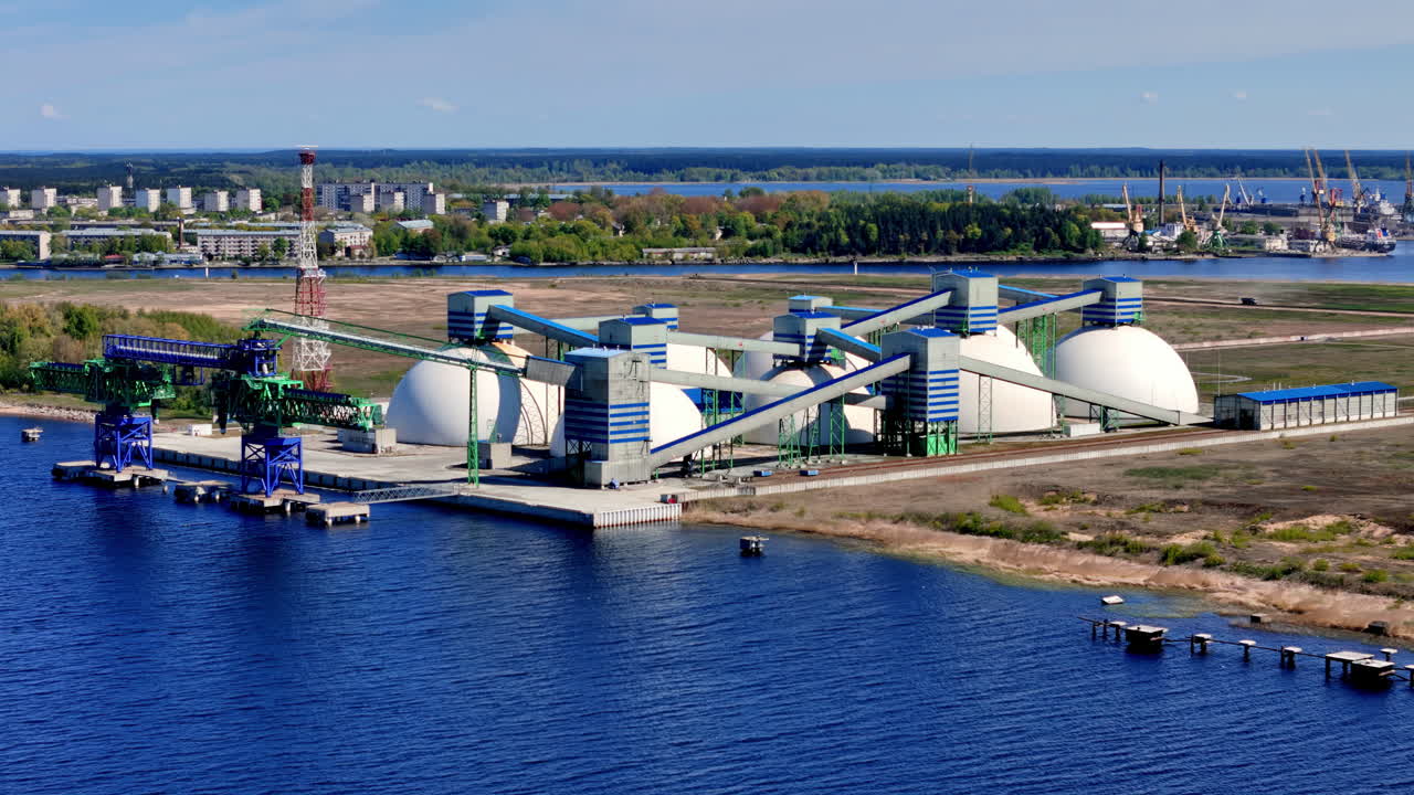 Elevated Mid-View of a Large Container Ship Docked at an Industrial Port, Actively Being Loaded or Unloaded by a Gantry Crane, Surrounded by Massive Stacks of Multi-Colored Containers