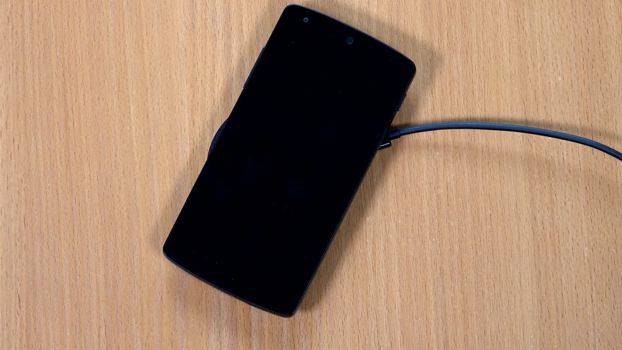 Mano maschile posiziona smartphone su caricabatterie wireless