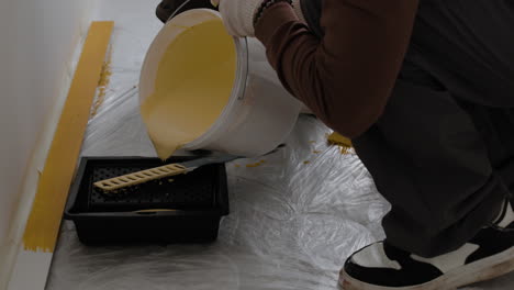 person painting a wall yellow
