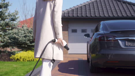 mujer cargando un coche eléctrico