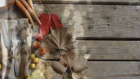 animation of light spots over cutlery and leaves on wooden background