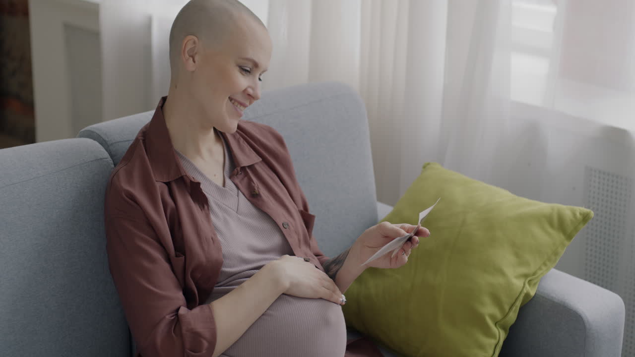 Pregnant Woman Reading a Card at Home