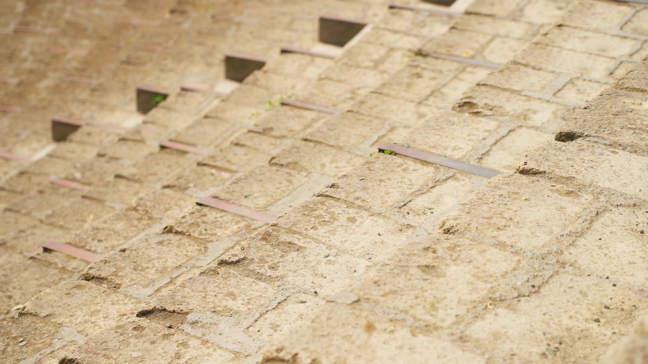 Close-up of ancient stone seating steps inside Pompeii’s Roman theater, showing worn masonry blocks, rough texture, and preserved archaeological details.