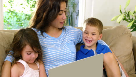 Mamá-Y-Sus-Hijos-Mirando-La-Computadora-En-Un-Sofá