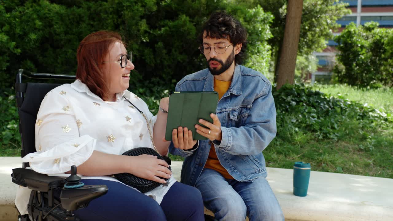 Two people looking at a tablet outdoors