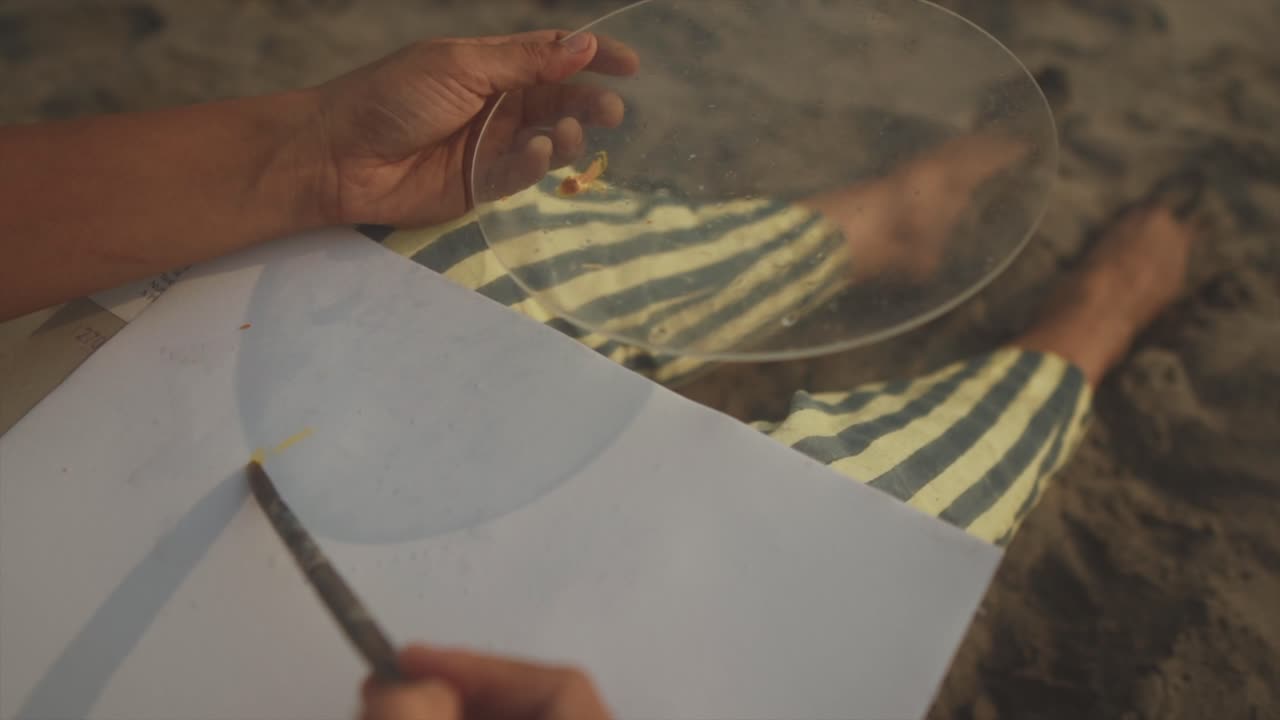 close-up shot of a girl painting using the sunlight shadows - close-up shots of a girl's hand painting on the paper
