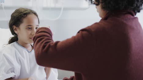 happy biracial mother playing with her sick daughter patient in hospital in slow motion