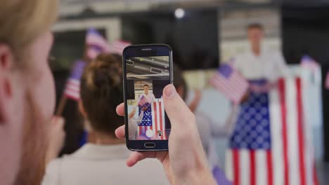 Audience-member-filming-political-rally-with-smartphone