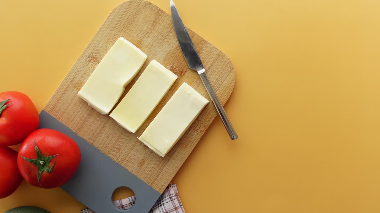 Sliced Cheese and Tomatoes on a Cutting Board