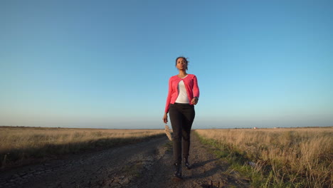 woman walking on a country road at sunset