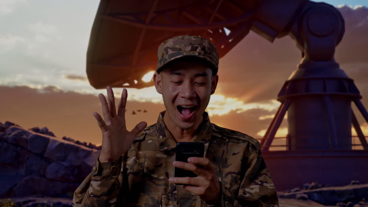 Close Up Of Asian Man Soldier Looking At Smartphone, Smiling, And Saying Wow While Standing With Satellite Dish