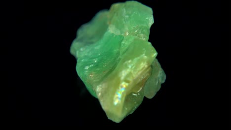 rotación sin problemas de un mineral de cal (calcita verde) frente a un fondo negro