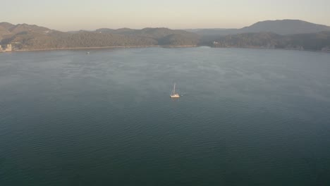 Weißer-Katamaran-Vor-Anker-In-Der-Nähe-Von-Winzigen-Inseln-Blaue-Türkisfarbene-Lagune,-Die-Die-Fabelhafte-Meereslandschaft-Rund-Um-Portugal-Erkundet