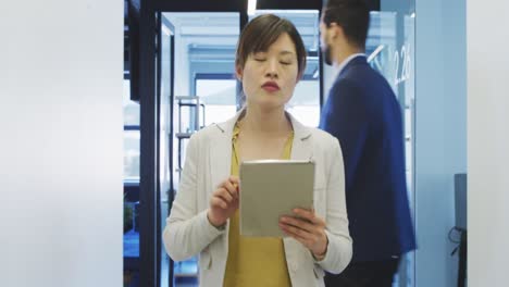 Mujer-De-Negocios-Trabajando-Mientras-Camina-En-Una-Oficina-Moderna