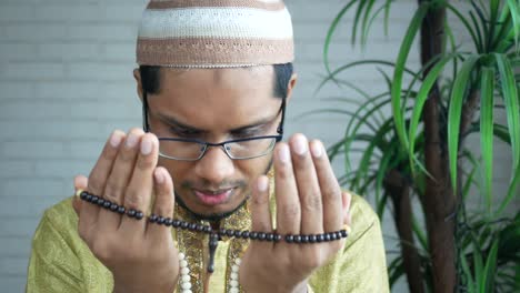 muslim man keep hand in praying gestures during ramadan, close up